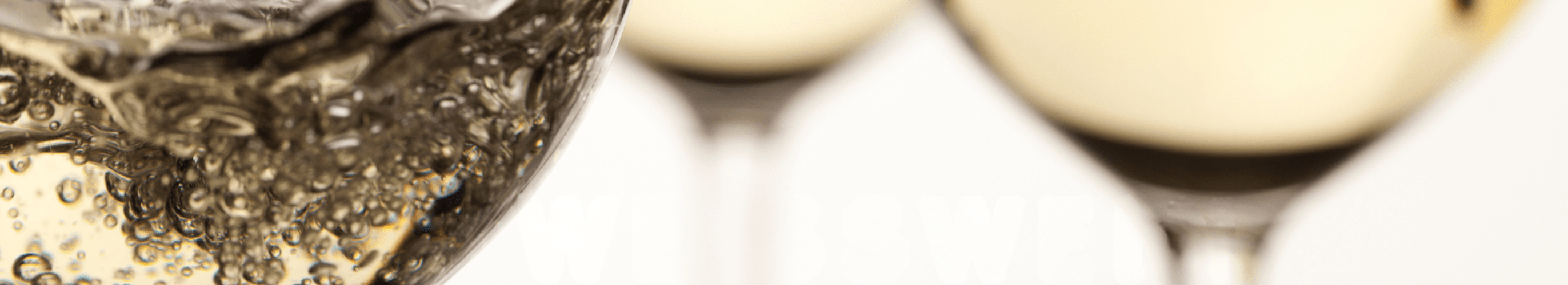Exklusive Nahaufnahme eines sprudelnden Weißweins im Glas mit zwei edlen Weingläsern im Hintergrund – Perfekter Mosel-Wein für Genussmomente.